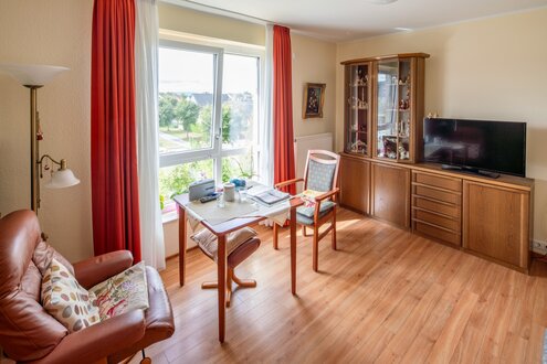 Helles, freundliches Wohnzimmer in einer betreuten Wohnanlage.